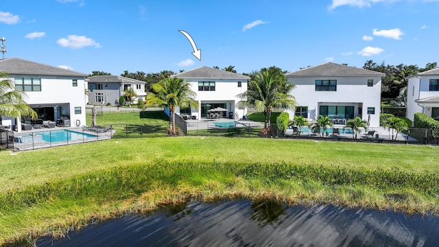 back of house featuring a lawn, a fenced in pool, and a patio