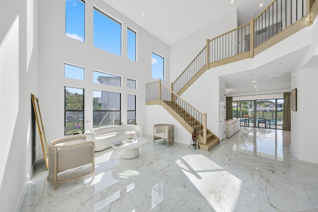 living room with plenty of natural light, a high ceiling, and french doors