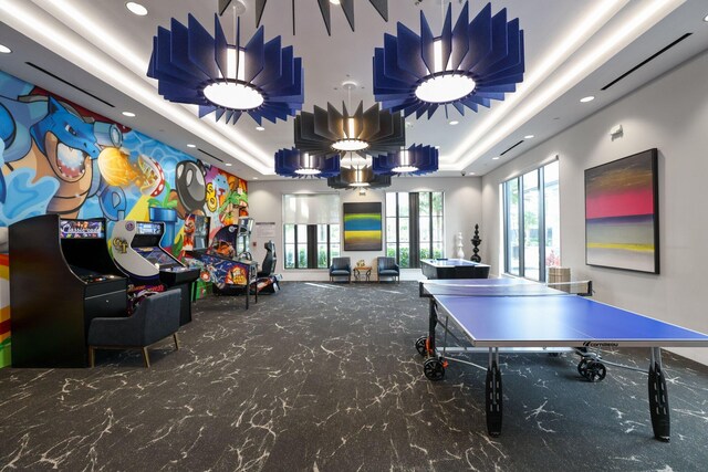 game room with carpet floors and a tray ceiling