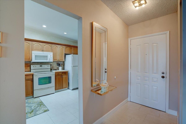 kitchen with light tile patterned flooring, white appliances, a textured ceiling, and vaulted ceiling