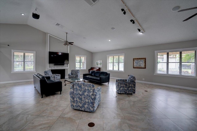 living room featuring light tile patterned floors, rail lighting, a textured ceiling, and ceiling fan