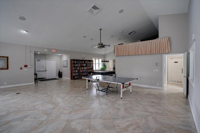 playroom with ceiling fan, high vaulted ceiling, and a textured ceiling