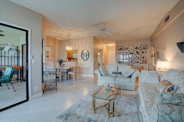 living room with ceiling fan with notable chandelier, a textured ceiling, and light tile patterned flooring