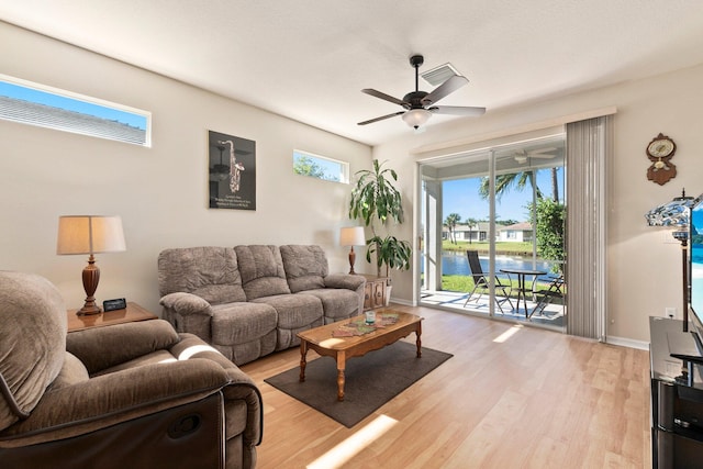 living room featuring ceiling fan and light hardwood / wood-style flooring