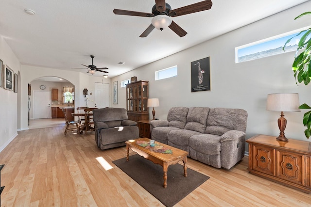 living room featuring ceiling fan, plenty of natural light, and light hardwood / wood-style floors