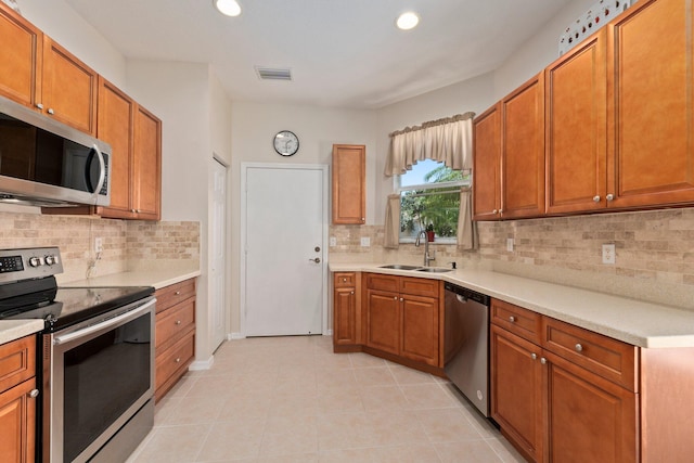 kitchen featuring light tile patterned floors, sink, appliances with stainless steel finishes, and tasteful backsplash