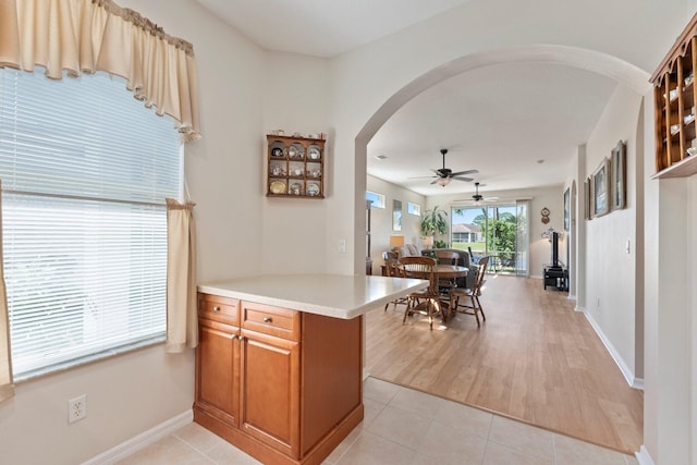 kitchen with kitchen peninsula, light wood-type flooring, and ceiling fan