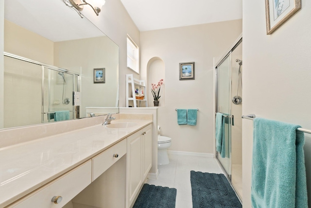 bathroom with tile patterned floors, vanity, toilet, and walk in shower