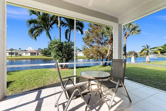 sunroom featuring a water view