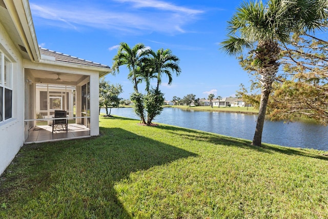 view of yard featuring a water view, a patio area, and a sunroom