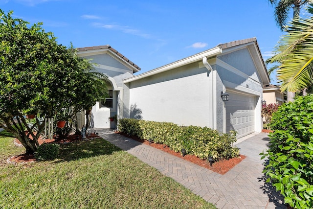 view of property exterior with a yard and a garage