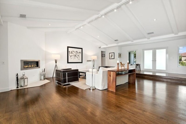 living room with a healthy amount of sunlight, dark hardwood / wood-style floors, vaulted ceiling with beams, and rail lighting