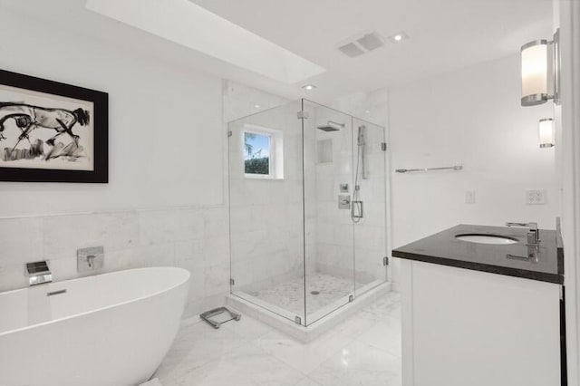 bathroom featuring vanity, tile walls, and plus walk in shower