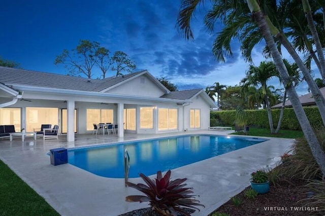 pool at dusk with a patio