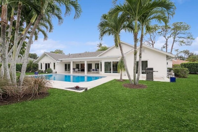 rear view of property featuring a patio and a yard