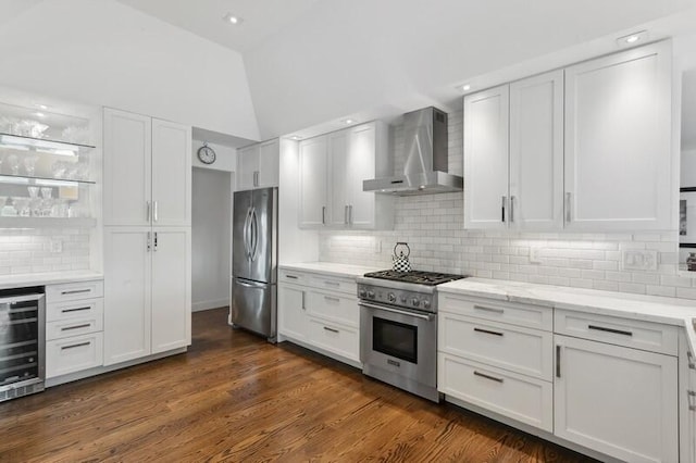 kitchen featuring stainless steel appliances, backsplash, beverage cooler, wall chimney range hood, and white cabinets