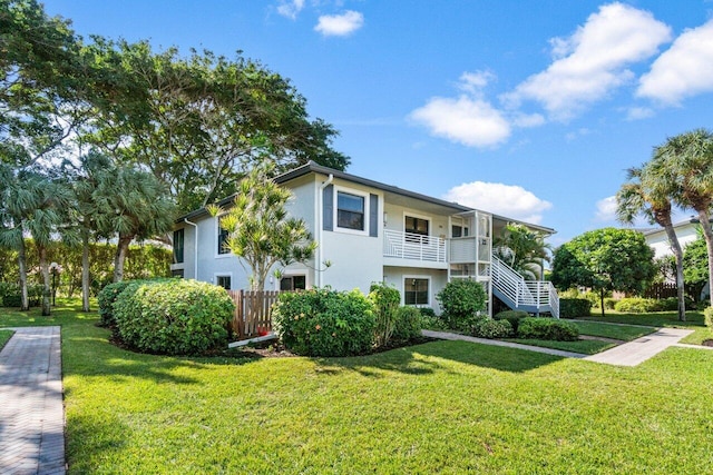 view of front of home featuring a balcony and a front yard