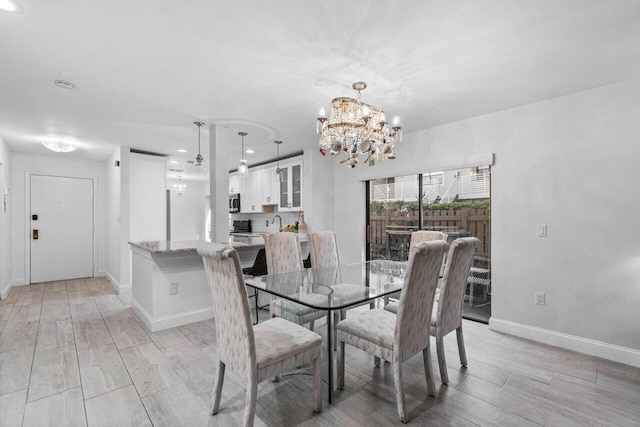 dining room featuring sink and a chandelier