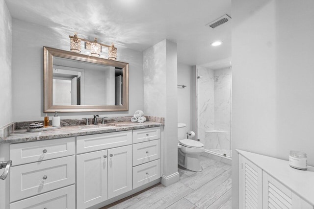 bathroom featuring vanity, toilet, and walk in shower