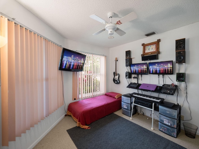 bedroom featuring ceiling fan, carpet floors, and a textured ceiling