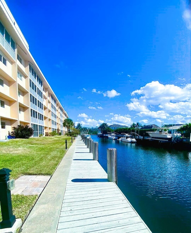 dock area with a yard and a water view