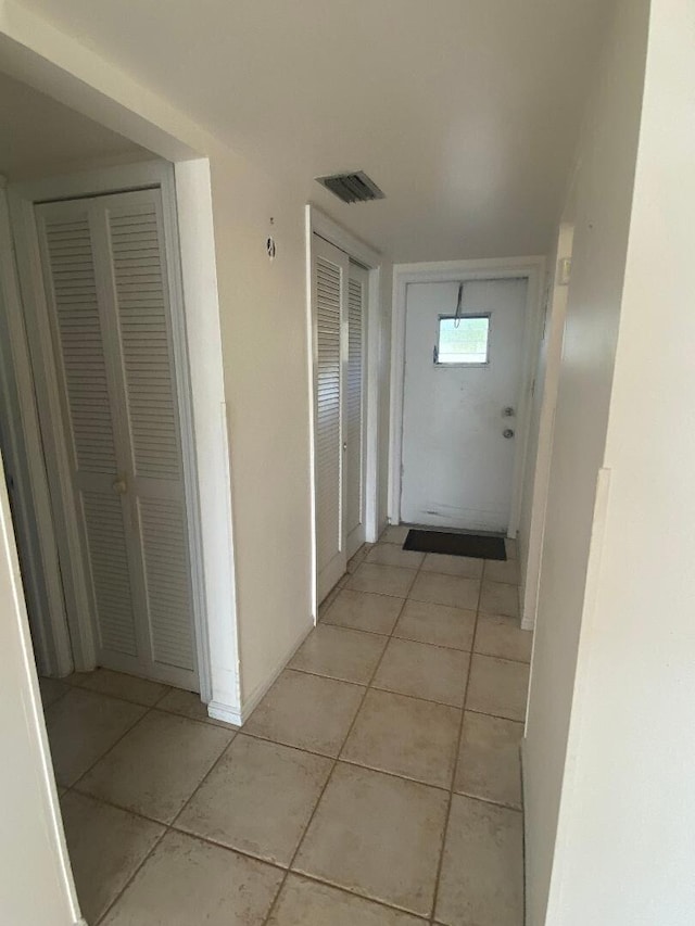 hall with light tile patterned floors and visible vents