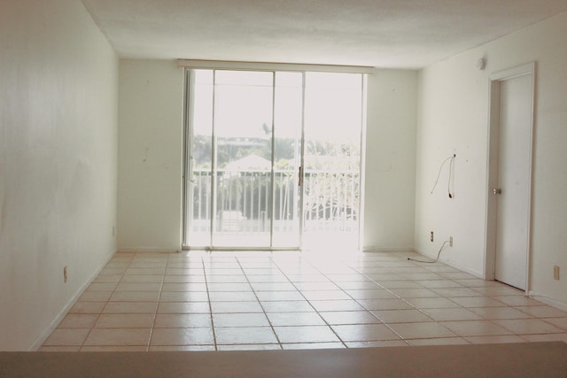 unfurnished room featuring expansive windows and tile patterned floors