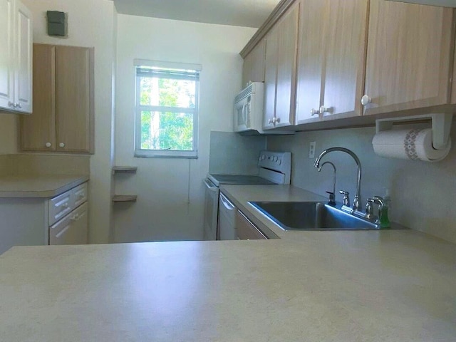 kitchen with light countertops, white microwave, range with electric stovetop, and a sink