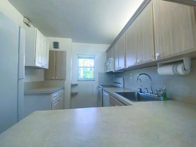 kitchen with light countertops, white appliances, and a sink