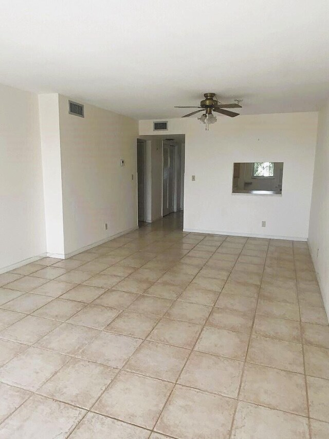 unfurnished room featuring light tile patterned floors, visible vents, and a ceiling fan