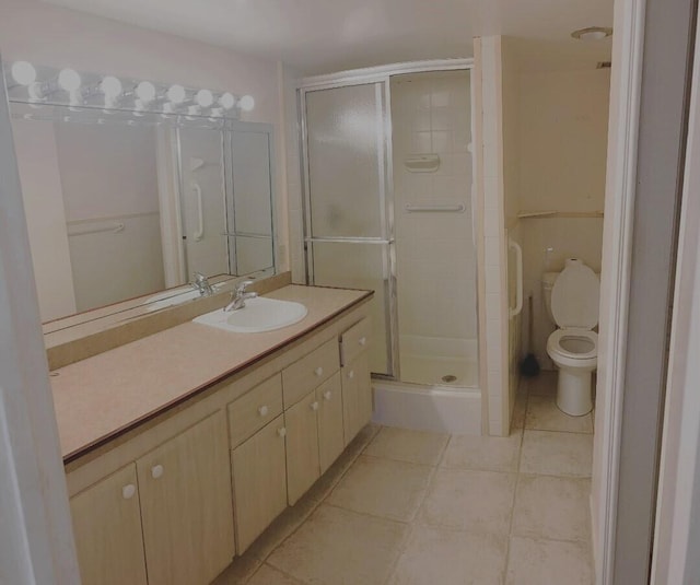 bathroom featuring toilet, a stall shower, tile patterned floors, and vanity