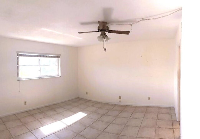 unfurnished room featuring ceiling fan, baseboards, and light tile patterned floors