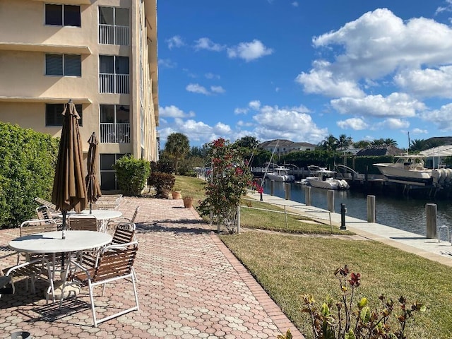 view of patio / terrace with a water view, a boat dock, and stairs