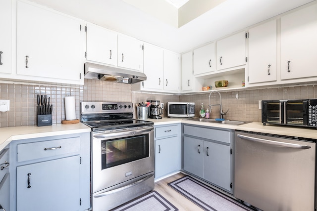 kitchen featuring sink, white cabinets, stainless steel appliances, and light wood-type flooring