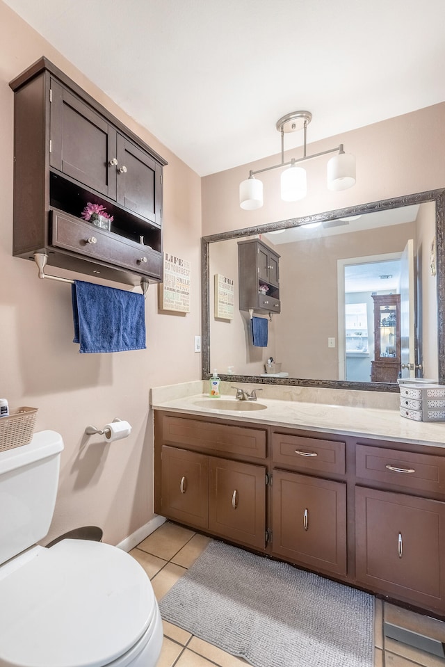 bathroom with tile patterned flooring, vanity, and toilet