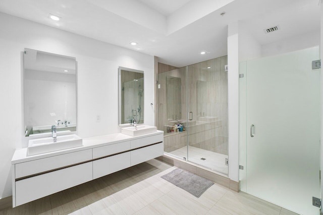 bathroom with tile patterned floors, a shower with door, and vanity