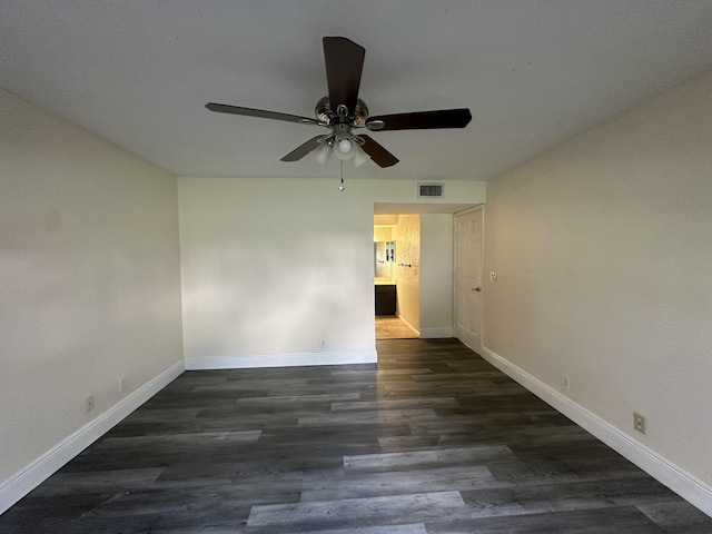 empty room with dark hardwood / wood-style flooring and ceiling fan