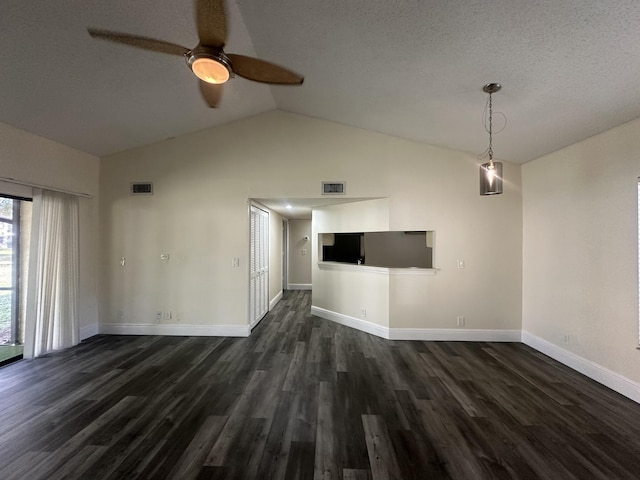 interior space with dark wood-type flooring, ceiling fan, vaulted ceiling, and a textured ceiling