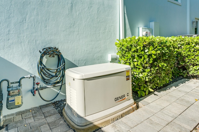 details with gas meter, electric meter, a power unit, and stucco siding