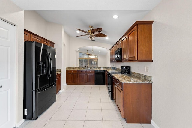 kitchen with light stone countertops, ceiling fan, lofted ceiling, light tile patterned floors, and black appliances