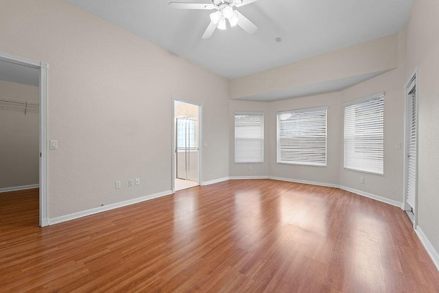 unfurnished bedroom featuring ceiling fan, light hardwood / wood-style floors, and a spacious closet