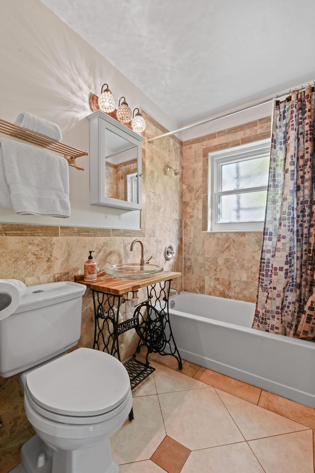 full bathroom with sink, tile patterned flooring, toilet, tile walls, and shower / tub combo