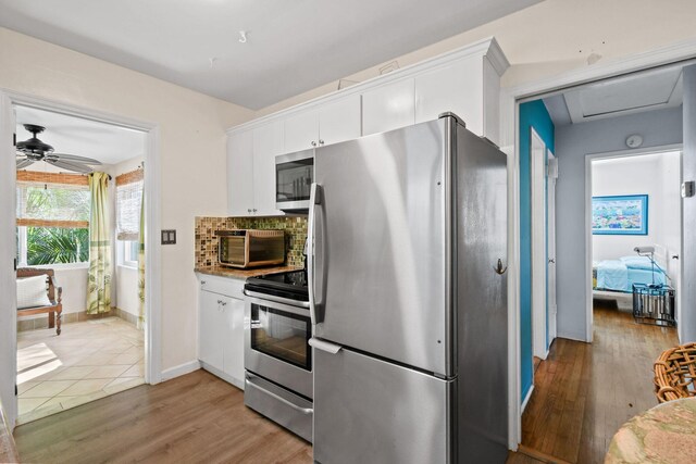 kitchen with backsplash, stainless steel dishwasher, a healthy amount of sunlight, sink, and white cabinetry