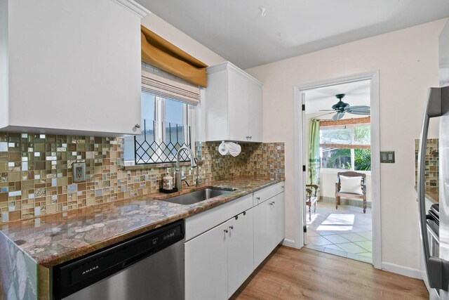 kitchen featuring decorative backsplash, stainless steel appliances, sink, light hardwood / wood-style floors, and white cabinetry