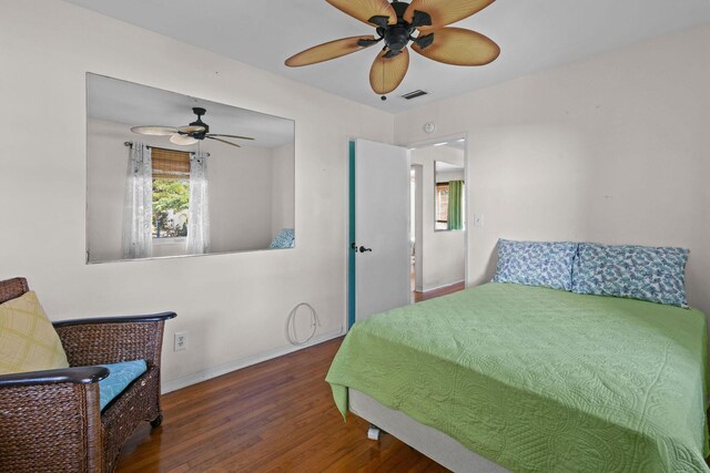 living area with a wealth of natural light, ceiling fan, and hardwood / wood-style flooring