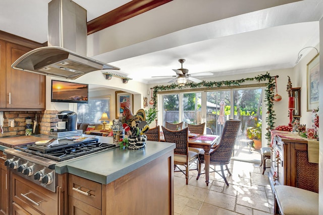 kitchen with backsplash, stainless steel gas stovetop, ceiling fan, and island exhaust hood