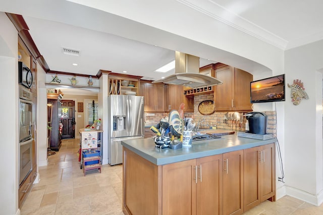 kitchen with island exhaust hood, stainless steel fridge, kitchen peninsula, decorative backsplash, and ornamental molding