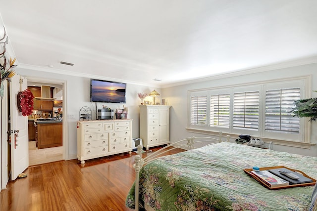 bedroom with wood-type flooring and ornamental molding