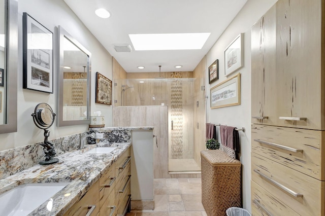 bathroom with vanity, a tile shower, and a skylight