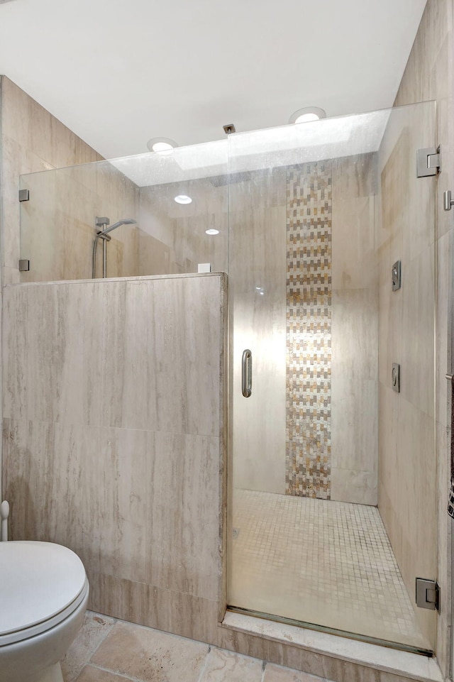 bathroom with toilet and a shower with shower door